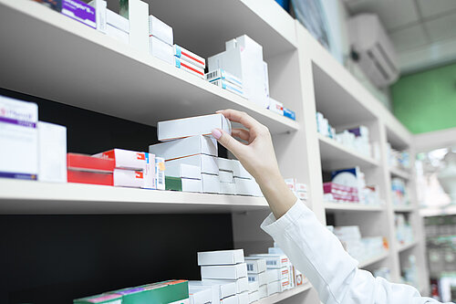 A pharmacist reaching for a box of medication