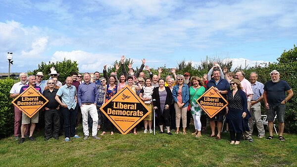 A large group of people with Liberal Democrat signs